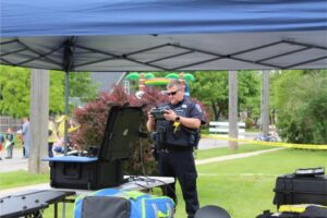 Police officer using equipment under canopy