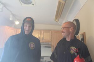 Two firefighters in a smoky kitchen