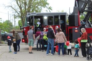 People exploring a fire truck outdoors.