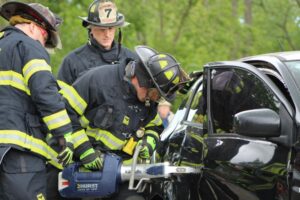 Firefighters using tools on a car