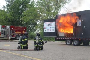 Firefighters observe a blazing trailer fire