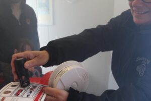 Person demonstrating smoke detector use